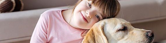 Child with down syndrome cuddling with dog