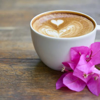 Kaffee mit lila Blume daneben