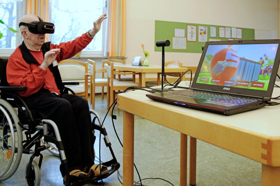 Älterer Mann im Rollstuhl spielt ein Spiel mittels einer mit VR-Brille.