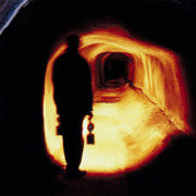 Ein Tunnel, der nut teilweise beleuchtet ist. Zu erkennen ist der Umriss eines Menschen.