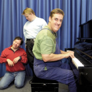 Drei Behinderte Künstler, einer spielt am Klavier.