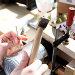 Jemand bastelt etwas aus einer Konservendose.