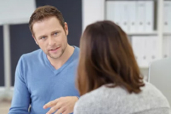 Foto von 2 Personen bei einem Beratungs·gespräch.