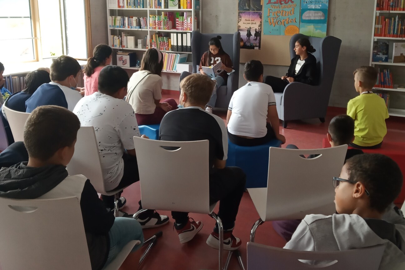 Interessiert hören die Fünftklässler den beiden Vorleserinnen zu.