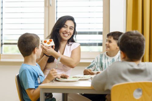 Kinderpflegerin beim Nachmittagssnack mit Kindern