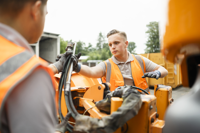 Montage am Winterfahrzeug durch zwei Nachwuchskräfte.