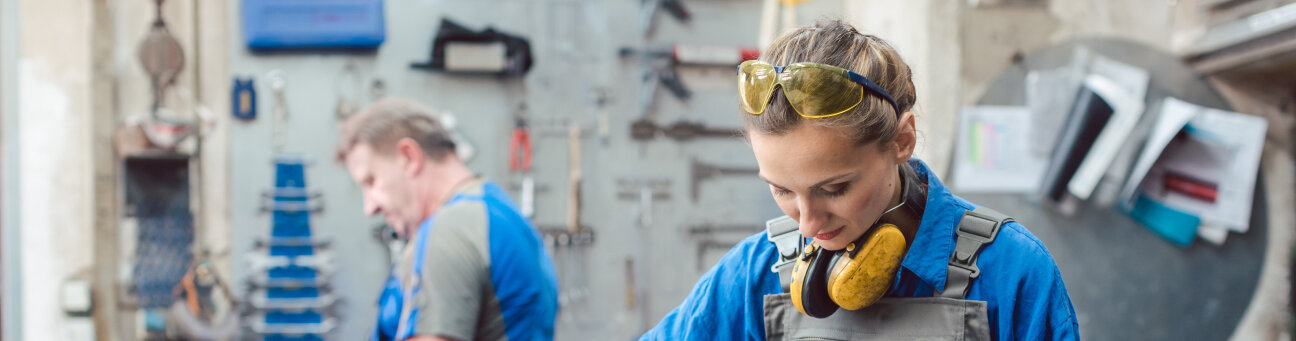 Man and woman working together in metal workshop with their tools, Bild © Kzenon
