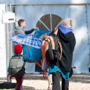 Mutter mit Kind auf dem Weg in ein Zelt im Flüchtlingscamp