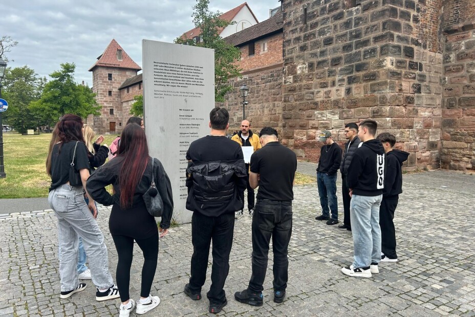 Schülerinnen und Schüler hören während des Rundgangs dem Gruppenleiter zu, Bild © Berufliche Schule 4 / Stadt Nürnberg