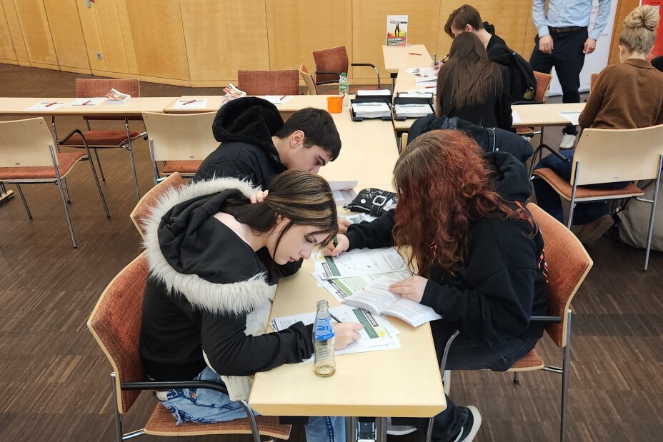 Schülerinnen und Schüler arbeiten an einem Tisch, Bild © Berufliche Schule 4 / Stadt Nürnberg