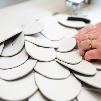Viele einzelne Stoffschuppen bilden später das Federkleid eines Storchkostüms.