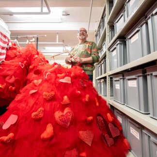 Im Fundus des Staatstheaters Nürnberg: Gunther Bickel mit einem ausladenden roten Bühnenkleid, an dem er mitgearbeitet hat.
