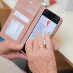 Ältere Person tippt auf Smartphone