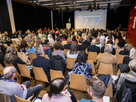 Bild © Rudi Ott / Stadt Nürnberg Foto: Viele Menschen sitzen in einem Tagungs·raum und hören einem Vortrag zu., Bild © Rudi Ott / Stadt Nürnberg