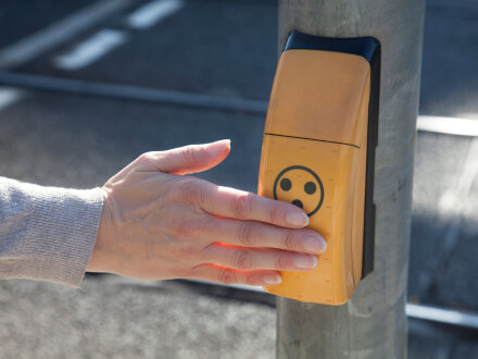 Das Bild zeigt eine Zusatz·einrichtung für Blinde und Menschen mit einer Seh·behinderung an einer Ampel.