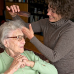 Ältere Dame mit Betreuerin beim Frisieren