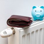 A stuffed wallet lying on the radiator and a small blue piggy ba