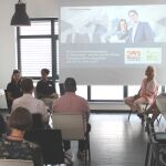 Man sieht eine Gruppe an Menschen, die einem Talk zuhören.