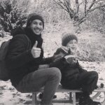 Mahmoud mit dem Enkel Jakob auf einem Schlitten in einer schneebedeckten Landschaft