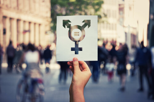 Hand hält ein Blatt mit Transgender-Symbol und Gleichheitszeichen innen. © Adobe Stock