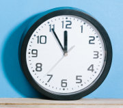 Das Bild zeigt eine Wand·uhr am Boden. Über der Uhr steht das Wort: Zeit·umstellung.