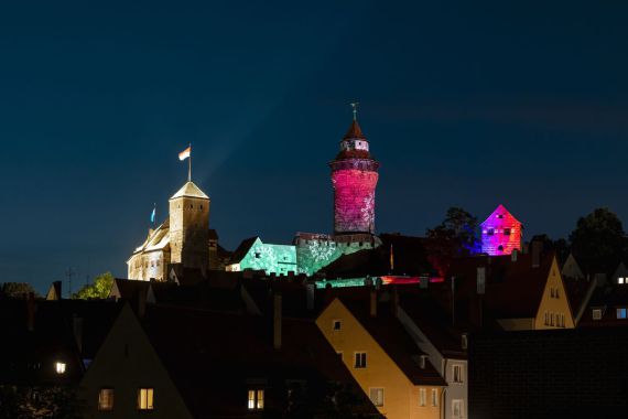 Lichtprojektion auf Kaiserburg in Grün- und Rottönen