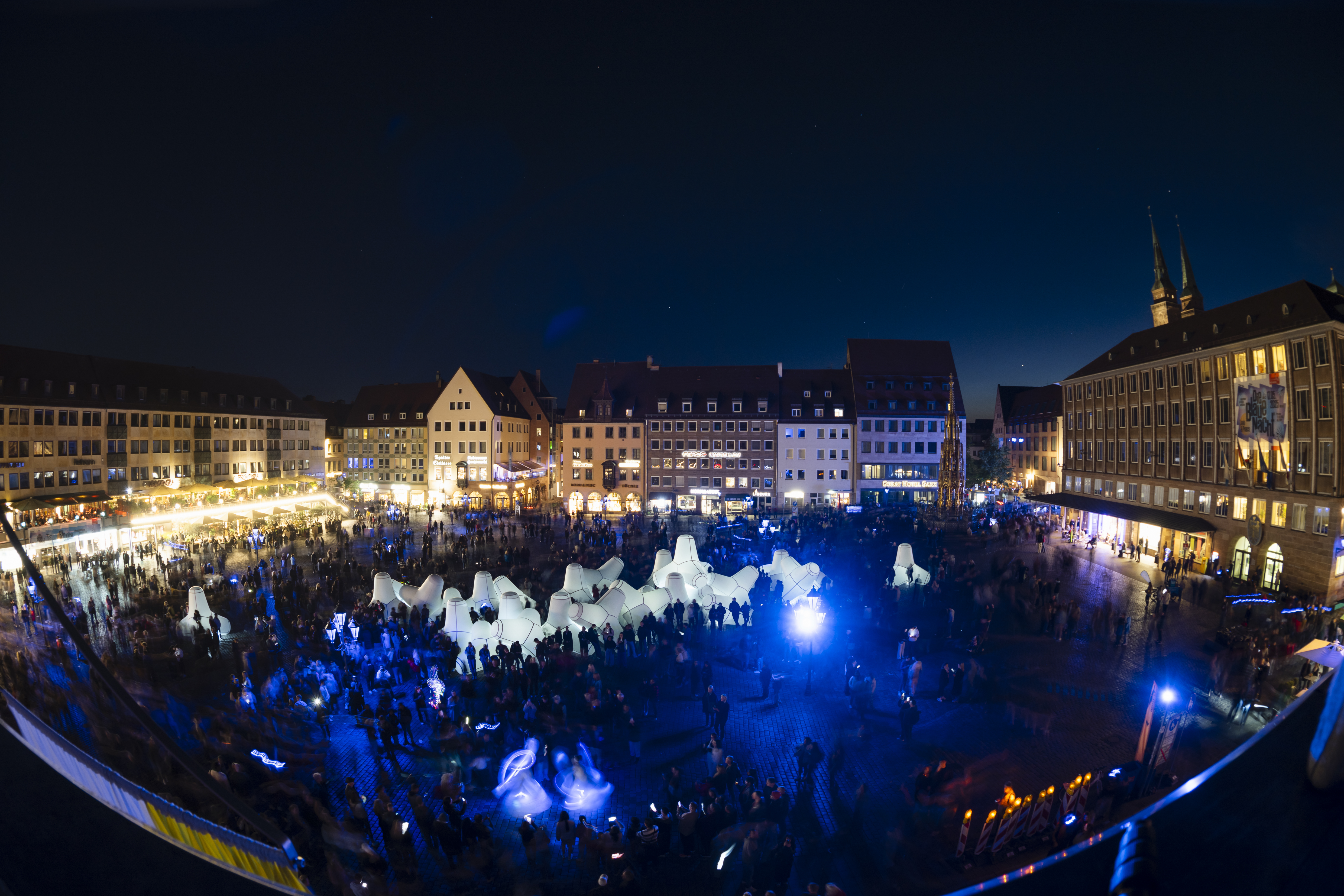 Aufnahme des Hauptmarkts von oben mit den weiß leuchtenden Luftobjekten der Kunstinstallation BYCATCH und zahlreichen Besucherinnen und Besuchern auf dem Hauptmarkt., Bild © UWE NIKLAS