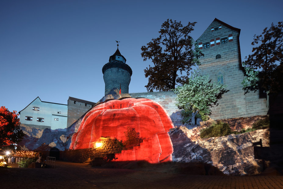 Auf die Kaiserburg wird ein roter Wackelpudding in Guglhupf-Form aus der Videoarbeit "HDGDL" von Rose Pistola projiziert., Bild © Ralf Moll