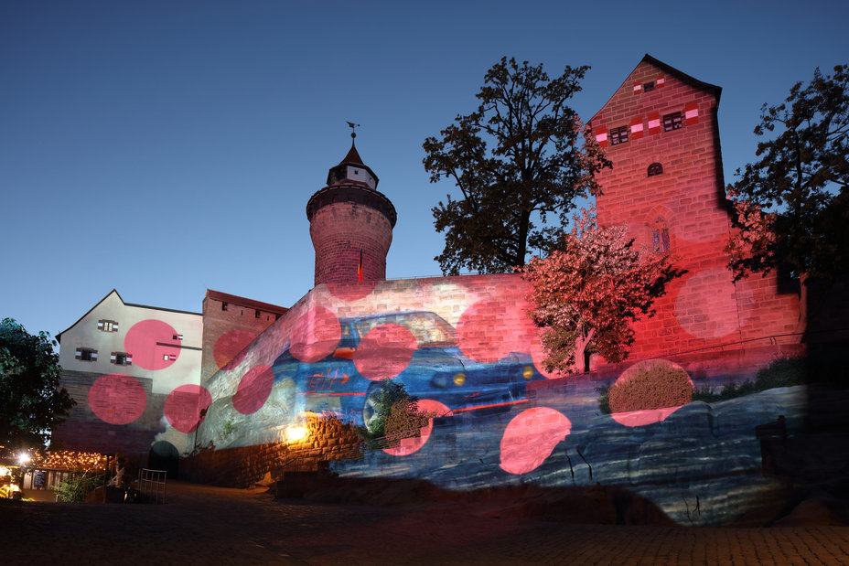 Auf die Kaiserburg werden pinke Kreise und ein Auto aus der Videoarbeit "HDGDL" von Rose Pistola projiziert., Bild © Ralf Moll