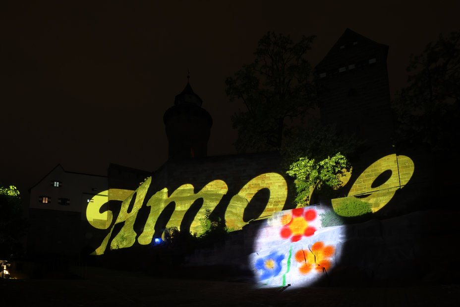 Auf die Kaiserburg wird der typografische Schriftzug "Amore" mit einem Blumenmotiv aus der Videoarbeit "HDGDL" von Holger Felten und Rose Pistola projiziert., Bild © Ralf Moll