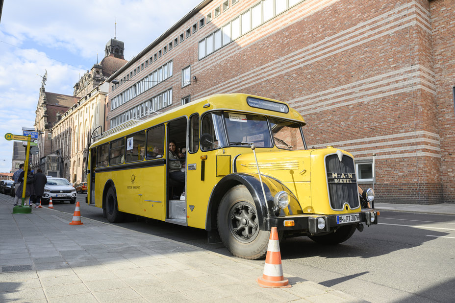 Ein gelber Postbus steht an der Haltestelle. Er war zur Blauen Nacht 2025 als Shuttle-Bus zwischen Hauptbahnhof und Museum für Kommunikation im Einsatz., Bild © (c) Steffen Kirschner l viaframe / Steffen Kirschner | viaframe