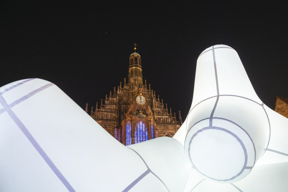 Große weiße Luftobjekte sind auf dem Hauptmarkt mit der Frauenkirche im Hintergrund installiert.