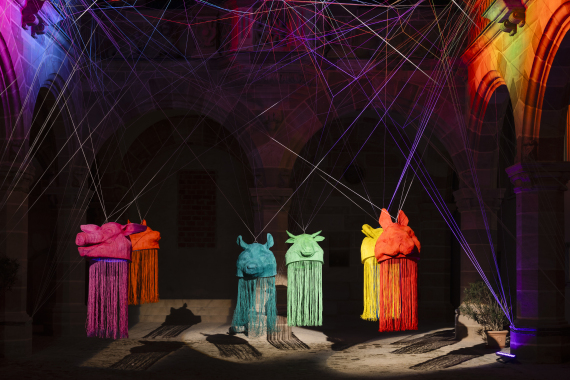 Das Werk "Hybrid Harmony" von Ines Fiegert entstand für den internationalen Blaue Nacht Kunstwettbewerb 2025. Sieben überdimensionale Tierköpfe schweben an einem Gespinst aus Nylonschnüren über der Freifläche. Ihre beleuchteten Oberflächen aus Nylonschnur setzen sich in kaskadenartigen Fäden bis zum Boden fort. Betritt man ihr Inneres, erwacht eine verborgene Welt aus Collagen und Musik. Ines Fiegert lebt und arbeitet in Rietheim/Deutschland. Das Werk wurde am 16. und 17. Mai 2025 im Pellerhaus im Rahmen der Blauen Nacht in Nürnberg gezeigt. Es wurde gefördert von KOCHINVEST.