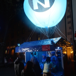 Verkaufsstand bei der Blauen Nacht 2015 mit beleuchtetem Ballon und dem Logo der Nürnberger Versicherung.