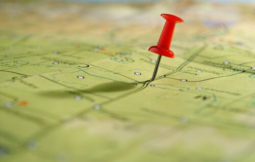 © sergign / stock.adobe.com Roter Pin auf einer grünen Landkarte © sergign / stock.adobe.com
