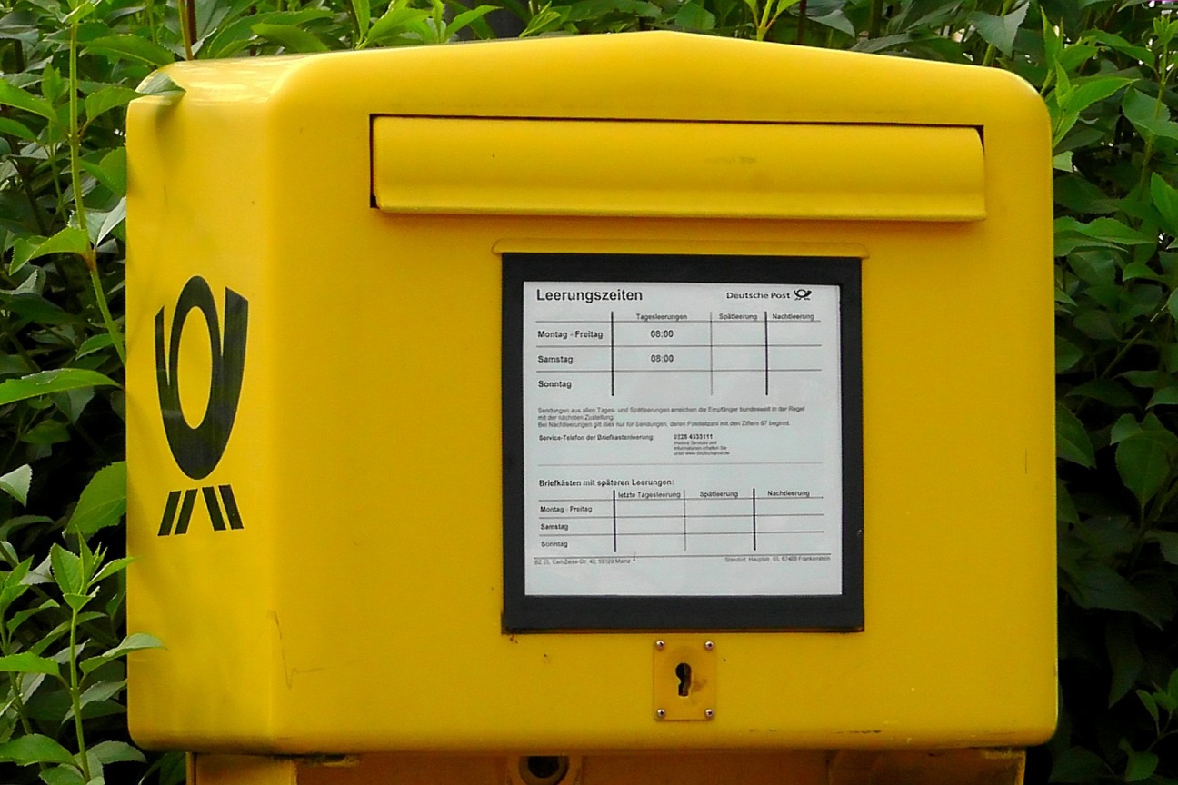 Gelber Briefkasten vor grünem Hintergrund, Bild © Schué / Pixabay