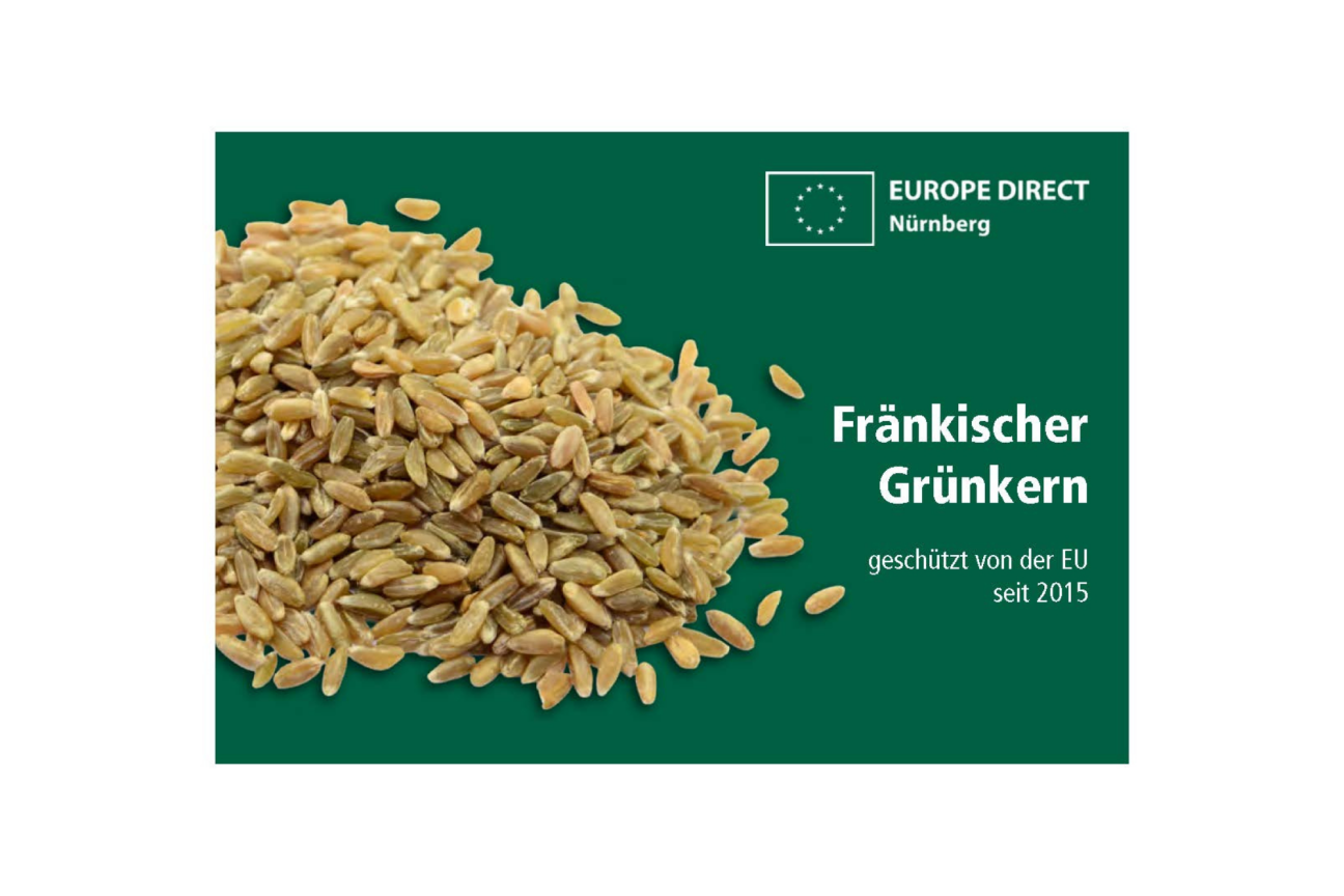 Bild © ED Nürnberg / Adobe Stock Ein Haufen fränkischer Grünkern vor grünem Hintergrund und dem EUROPE DIRECT Nürnberg Logo. Der Text sagt Fränkischer Grünkern geschützt von der EU seit 2015., Bild © ED Nürnberg / Adobe Stock
