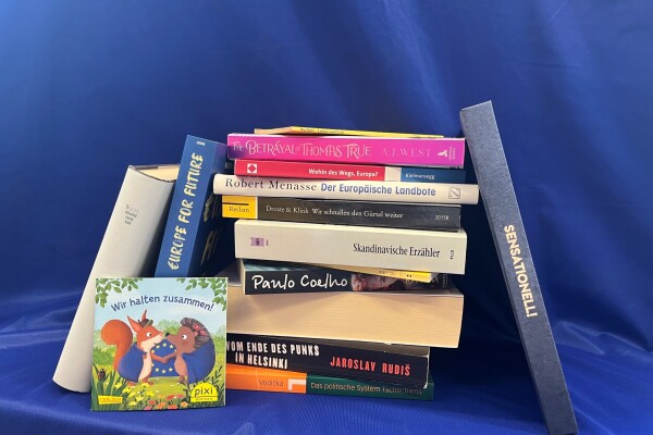 Ein Bücherstapel vor einer Europaflagge