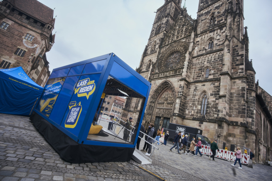 Bild © Europäische Kommission Vertretung in Deutschland Der Cube, das mobile Podcaststudio der #LassReden-Kampagne, vor der Lorenzkirche., Bild © Europäische Kommission Vertretung in Deutschland
