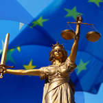 Justitia Statue mit Schwert und Waage vor einer EU-Flagge