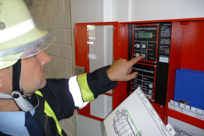 Feuerwehrmann an einer Brandmeldeanlage, Bild © Feuerwehr Nürnberg