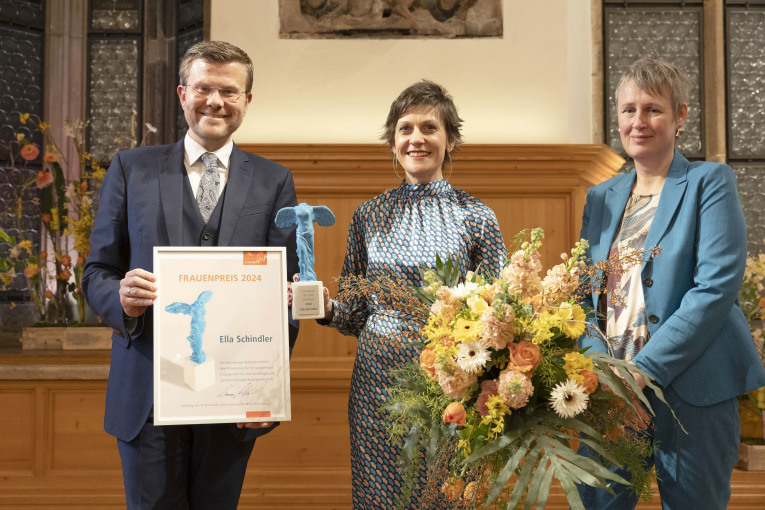 Oberbürgermeister Marcus König und Hedwig Schouten, Frauenbeauftragte der Stadt Nürnberg, verleihen den Frauenpreis 2024 an Ella Schindler