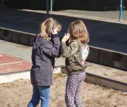 Zwei Mädchen nehmen im Schulhof verschiedene Geräusche mit einem Aufnahmegerät auf