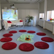 Zimmer mit roten Teppichen und Hängematte.