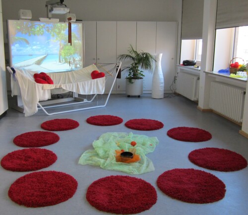 Zimmer mit roten Teppichen und Hängematte.