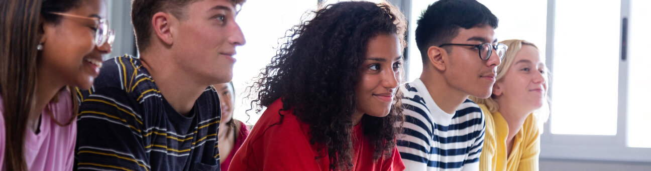 Black female high school student in class with multiracial classmates. African american college student in class with multiethnic friends. Education concept.