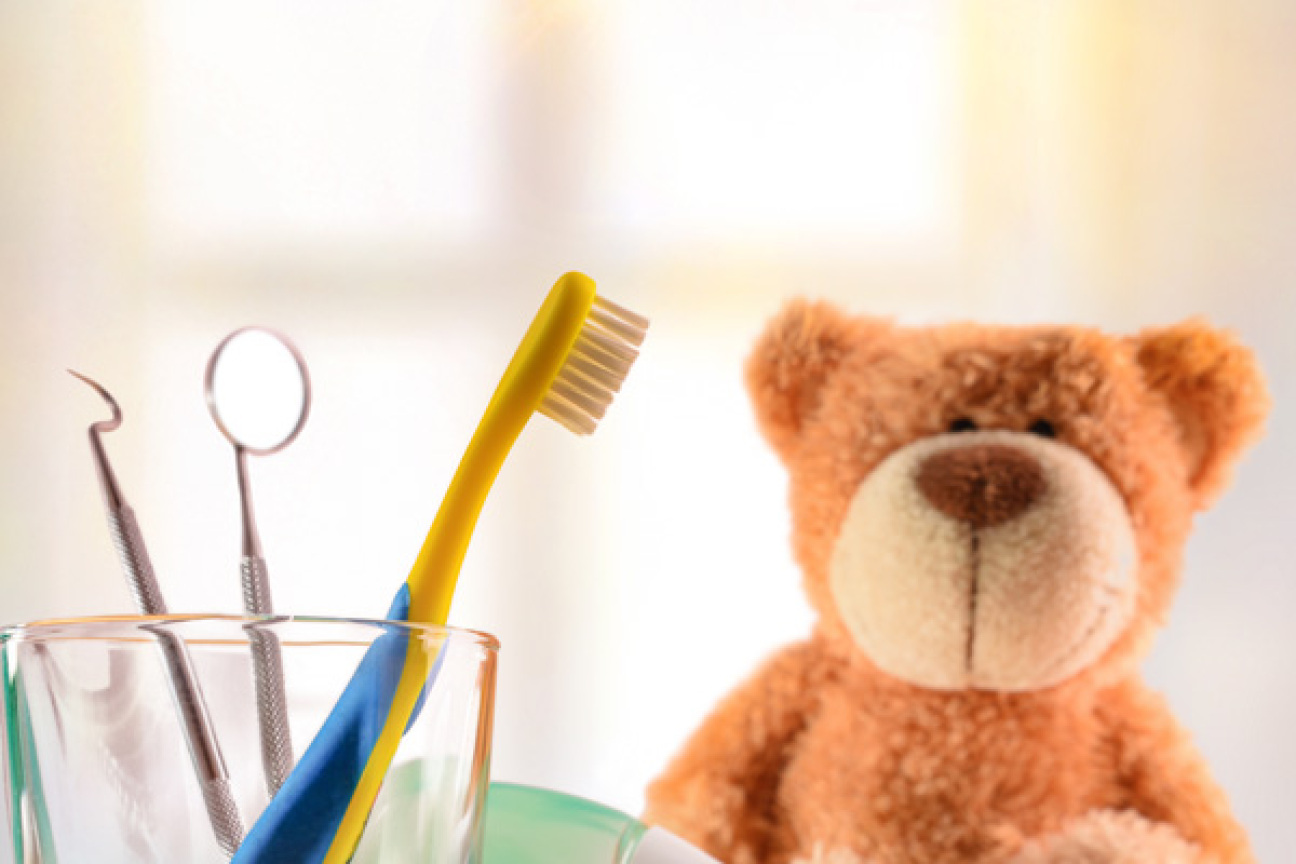 Glas mit Zahnbürste, Zahnarztutensilien und Teddybär., Bild © Davizro Photography / stock.adobe.com