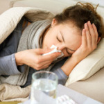 Eine junge Frau liegt mit einer Atemwegserkrankung auf dem Sofa.