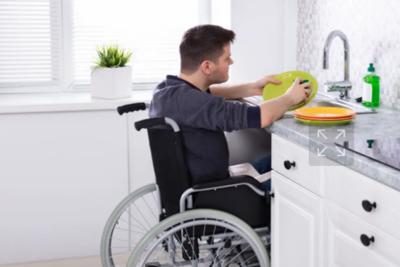 Mann im Rollstuhl an einer unterfahrbaren Küchenzeile