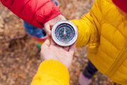 Kinder halten einen Kompass in den Händen.